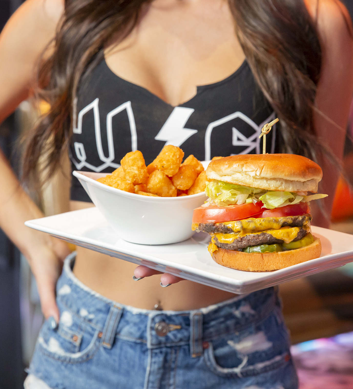 Woman Holding Burger and Tater Tots